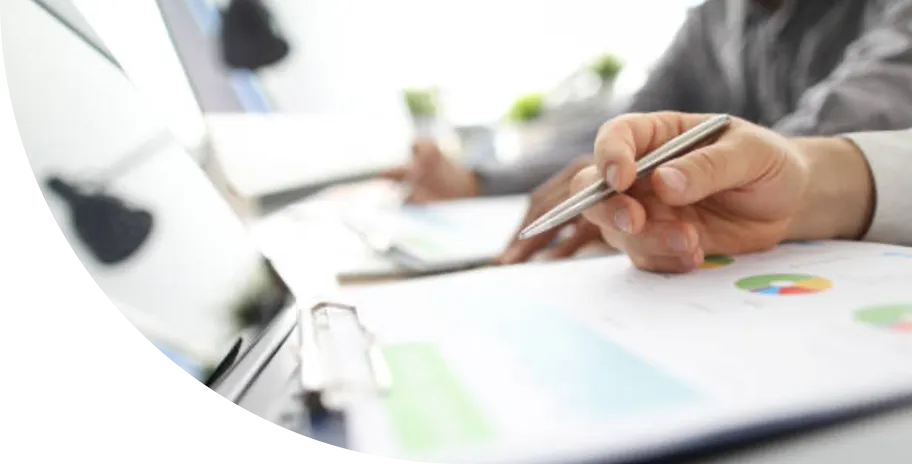 A person sitting at a desk with a pen in their hand.